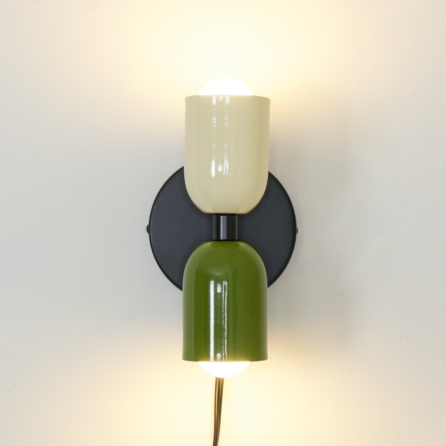 Up and down wall lamp adding soft light to a styled space