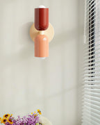 Coloured wall lamp glowing warmly in a styled space