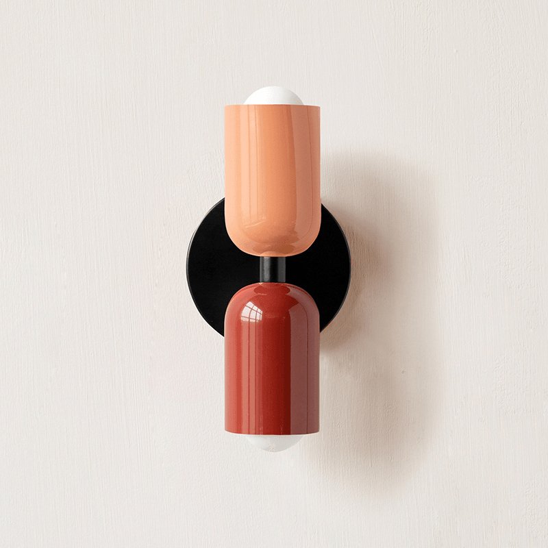 Up-down wall lamp mounted in a soft-lit hallway