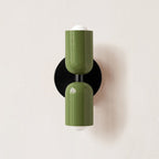Wall lamp with coloured metal shade glowing in an interior