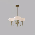 Persimmon chandelier with creamy glass globes lit in a warm interior