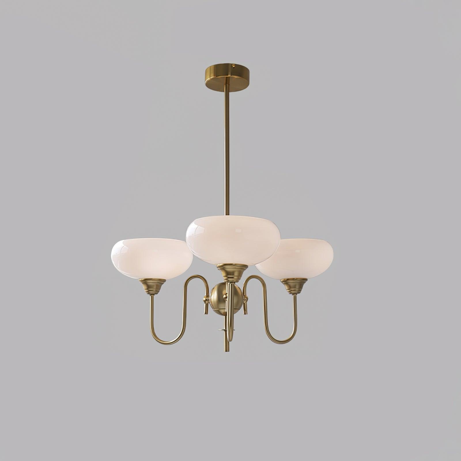 Persimmon chandelier with creamy glass globes lit in a warm interior