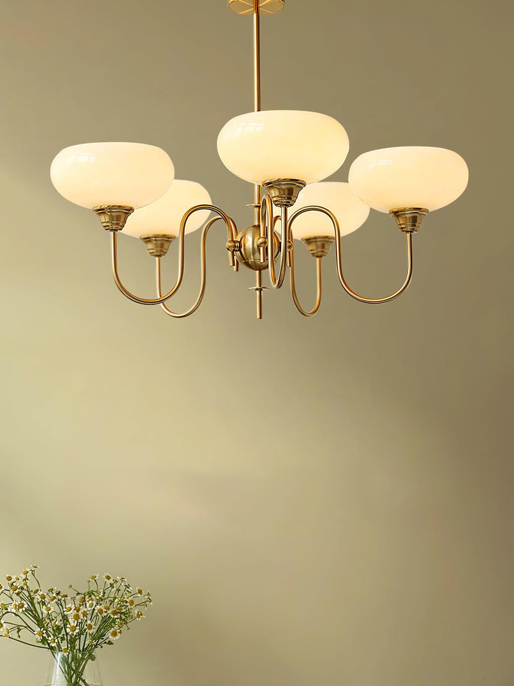 Persimmon chandelier with smooth creamy glass globes lit warm