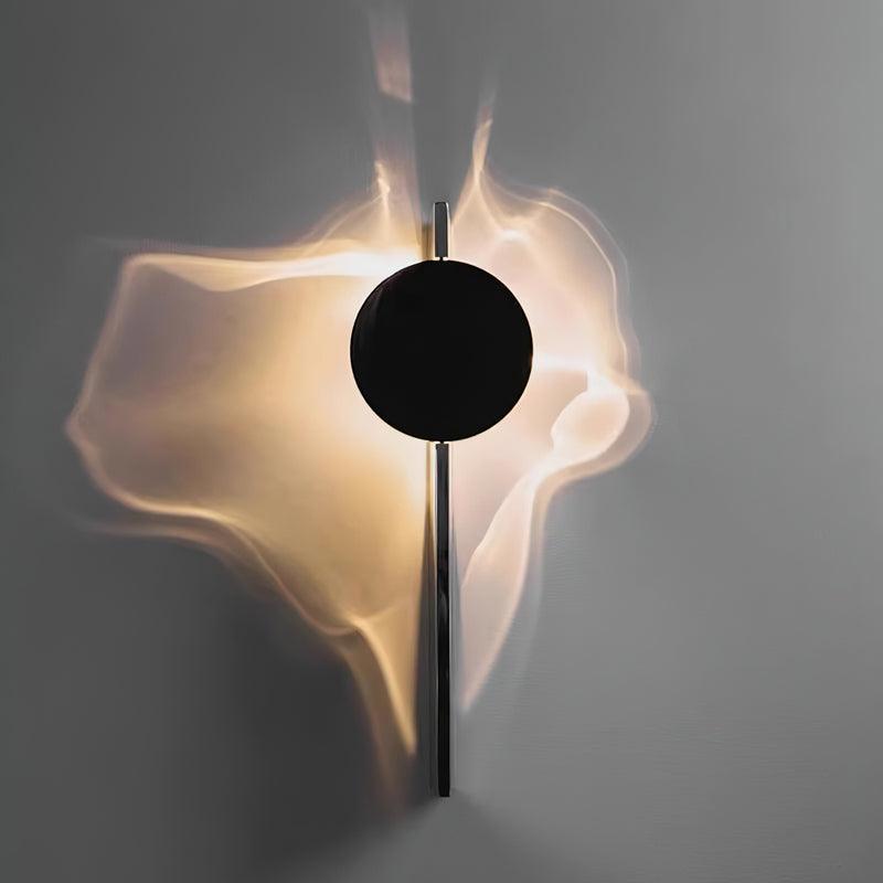 Chrome wall lamp casting shifting light and shadow on a wall