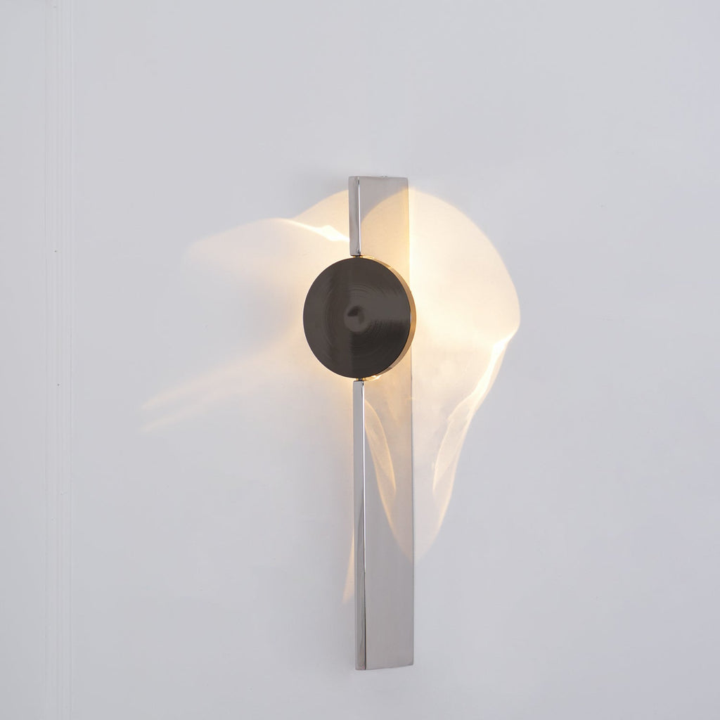 Slim sculptural chrome wall lamp with cool-toned LED glow