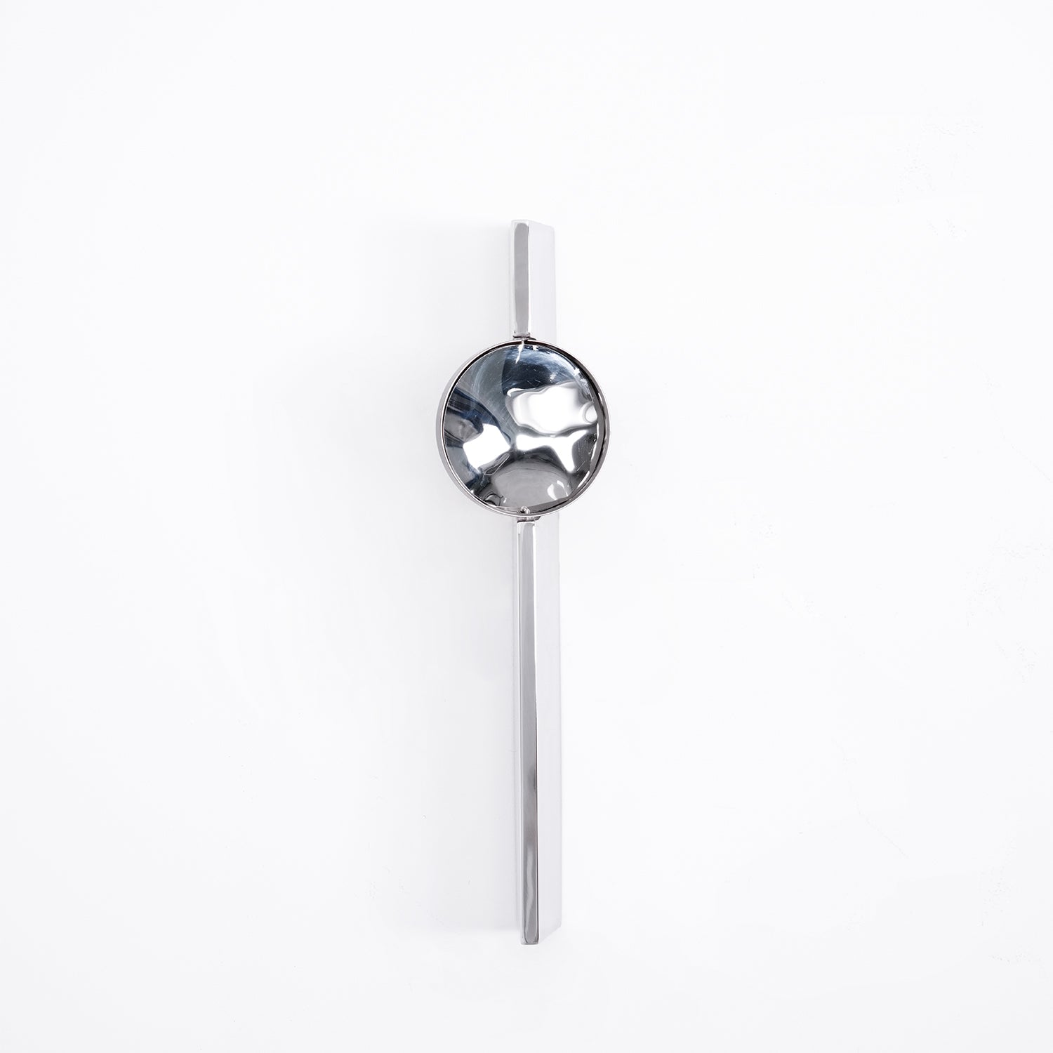 Mirrored chrome wall lamp throwing layered light on a wall