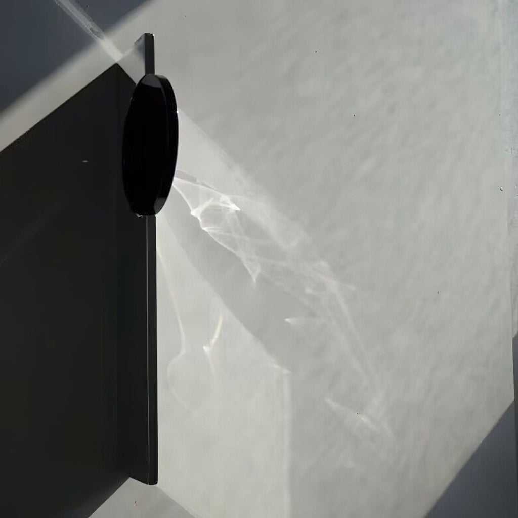 Sculptural chrome wall lamp reflecting warm refracted light