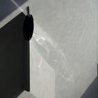 Sculptural chrome wall lamp reflecting warm refracted light