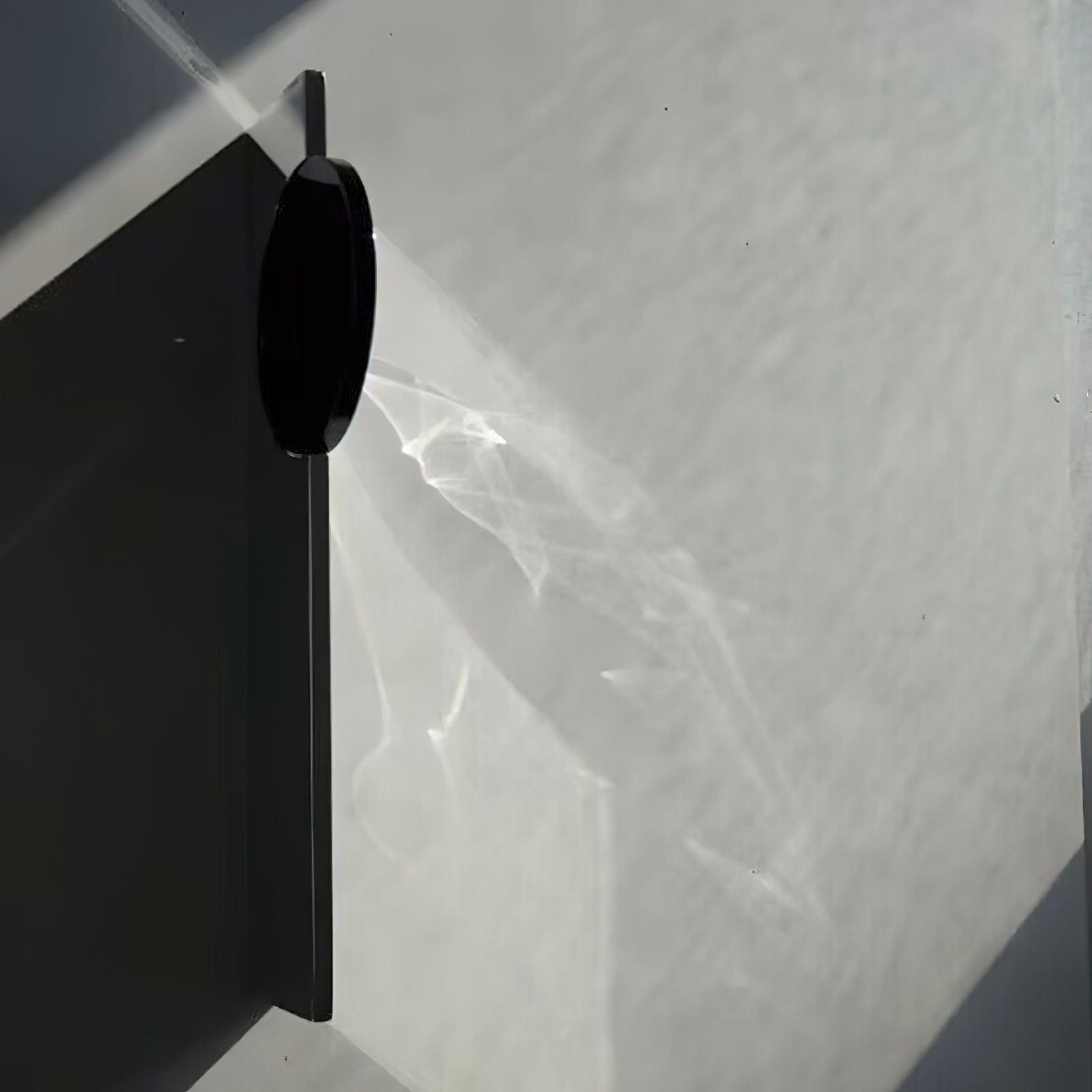 Sculptural chrome wall lamp reflecting warm refracted light