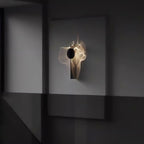 Mirrored chrome wall lamp shown close up with black shade