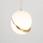 Hanging low with extra cord showing above, this Clérachic pendant glows softly against a plain grey backdrop.
