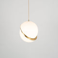 Photographed face-on with even light, this Clérachic pendant's brass crescent sits centred on the sphere.