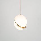 Photographed face-on with even light, this Clérachic pendant's brass crescent sits centred on the sphere.