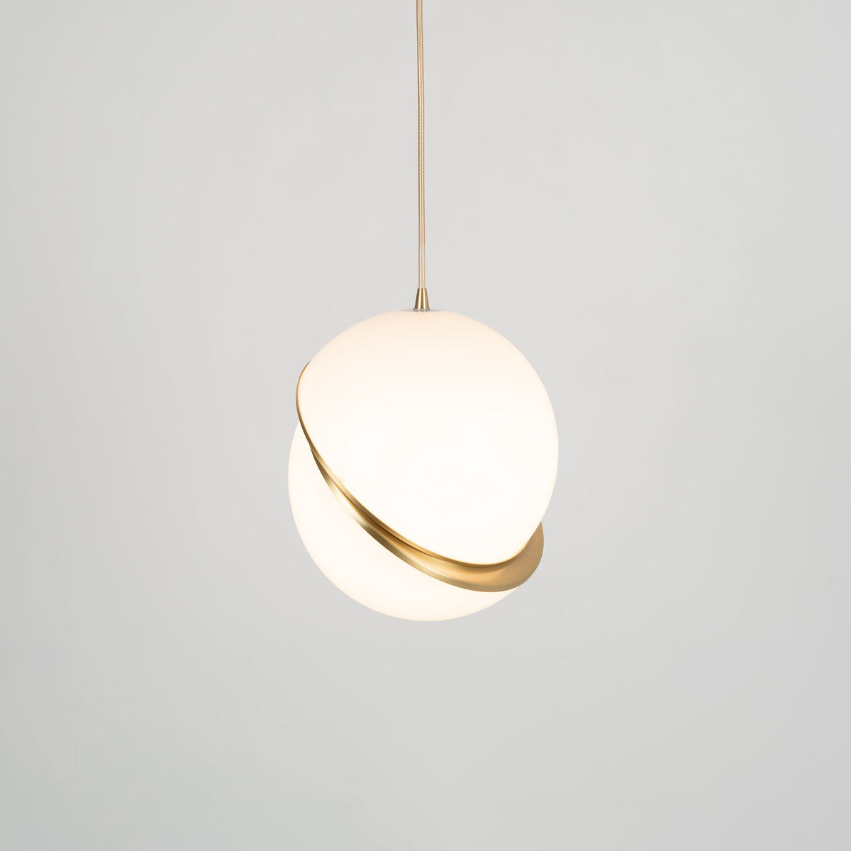 Photographed face-on with even light, this Clérachic pendant's brass crescent sits centred on the sphere.