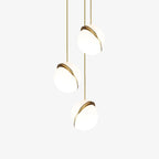 On a plain white backdrop, three brass-crescent pendants of this Clérachic fixture cluster on slender cords.