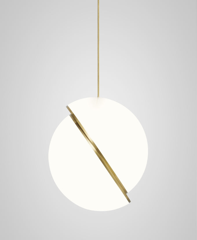 Photographed at a steep angle, this Clérachic pendant's brass crescent cuts diagonally across the sphere.