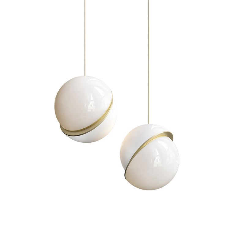 On a white backdrop, two brass-crescent pendants of different sizes hang side by side, from Clérachic.