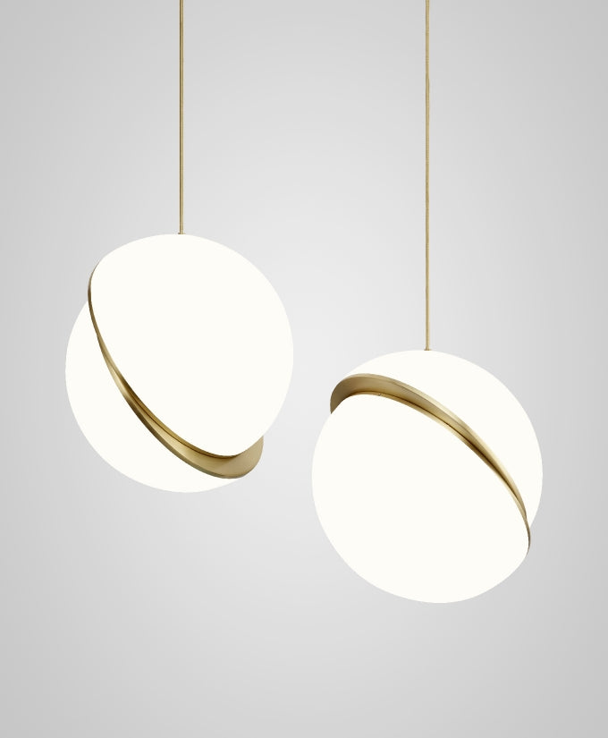 Side by side on brass cords against a plain grey backdrop, two of this Clérachic pendant hang.
