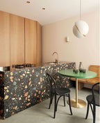 Above a terrazzo kitchen island with a green side table, a single Clérachic pendant hangs.