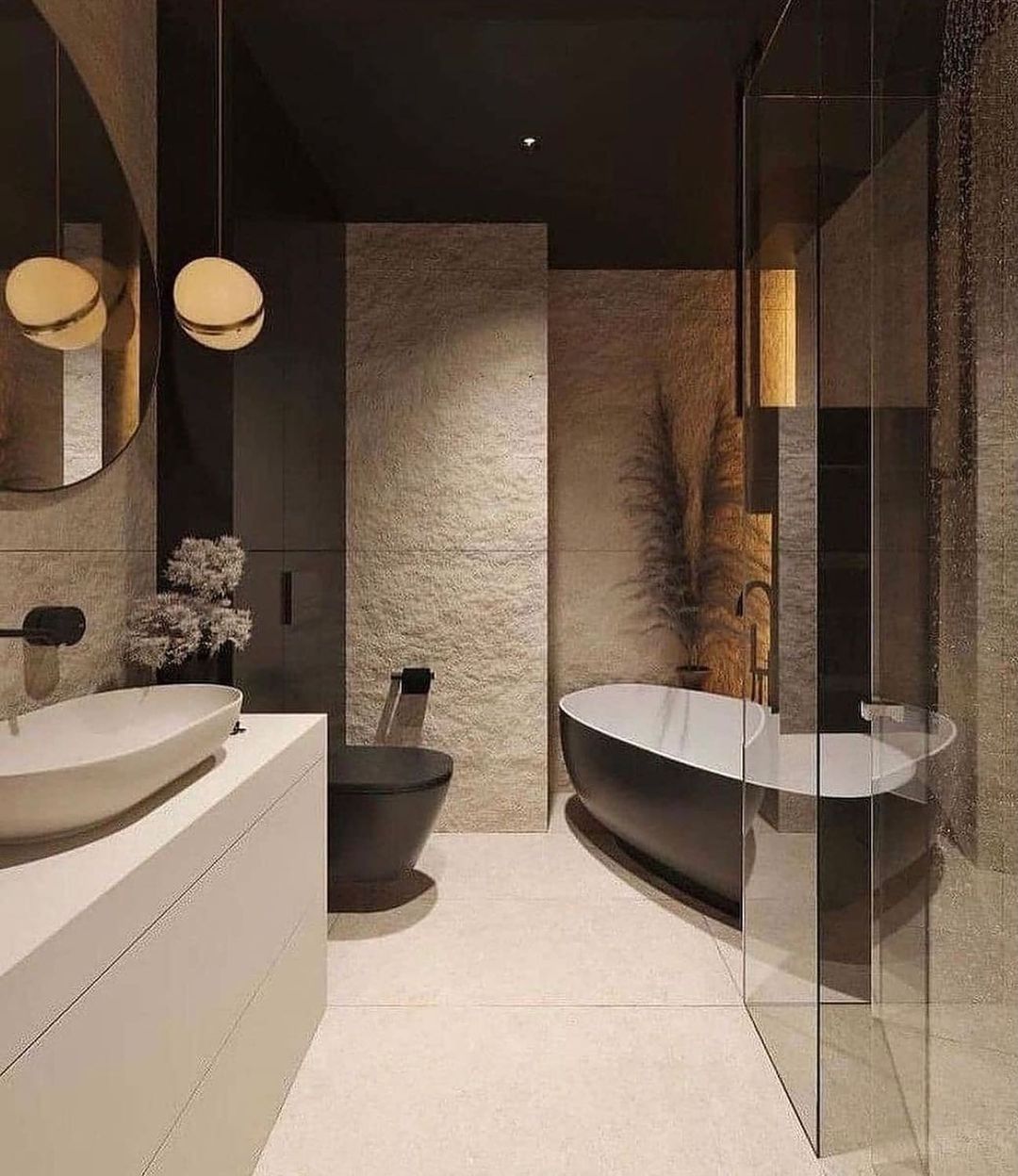 Beside a dark stone bathroom with a freestanding tub, two of this Clérachic pendant hang.