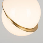 Close view of the brass crescent band wrapped around this Clérachic pendant's glossy sphere.
