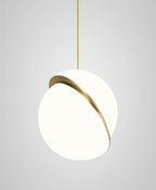 This Clérachic pendant hangs with its brass crescent set near the top of the sphere, on a grey backdrop.