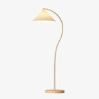 Pleated linen floor lamp with a beech wood frame lighting a styled living room