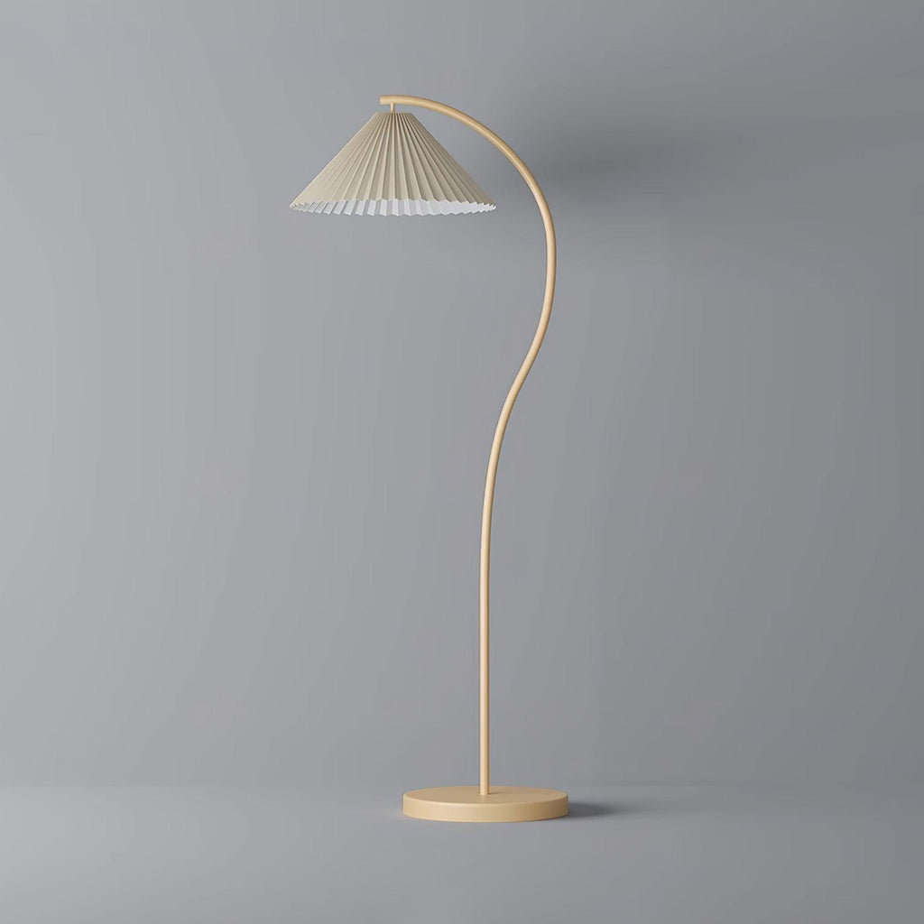 Floor lamp with pleated beige shade glowing at dusk