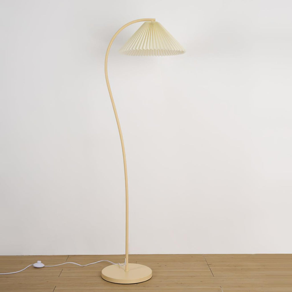 Pleated floor lamp adding warm light to a bedroom corner