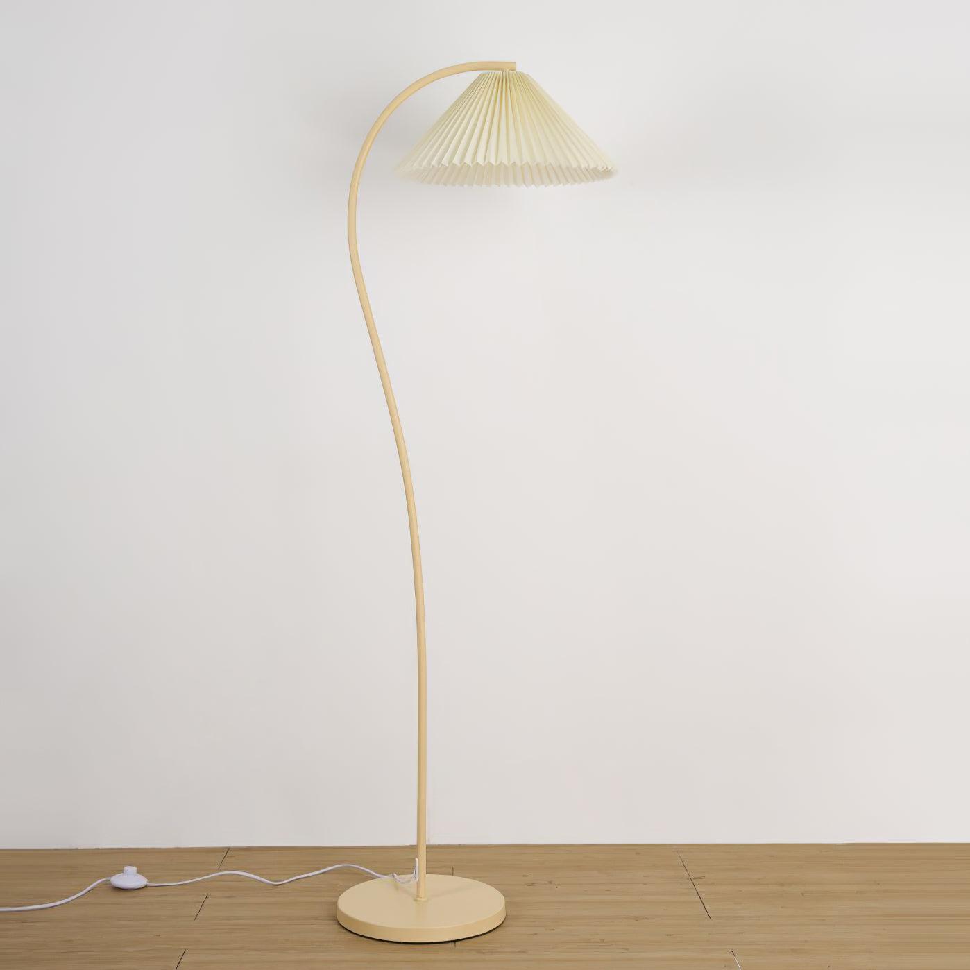 Pleated floor lamp adding warm light to a bedroom corner