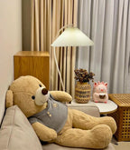 Pleated linen shade glowing on the floor lamp at close range