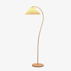 Pleated floor lamp standing beside a chair in a reading corner