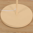 Pleated linen floor lamp lit beside a sofa in the evening