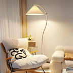 Floor lamp with pleated linen shade lit in a softly furnished room