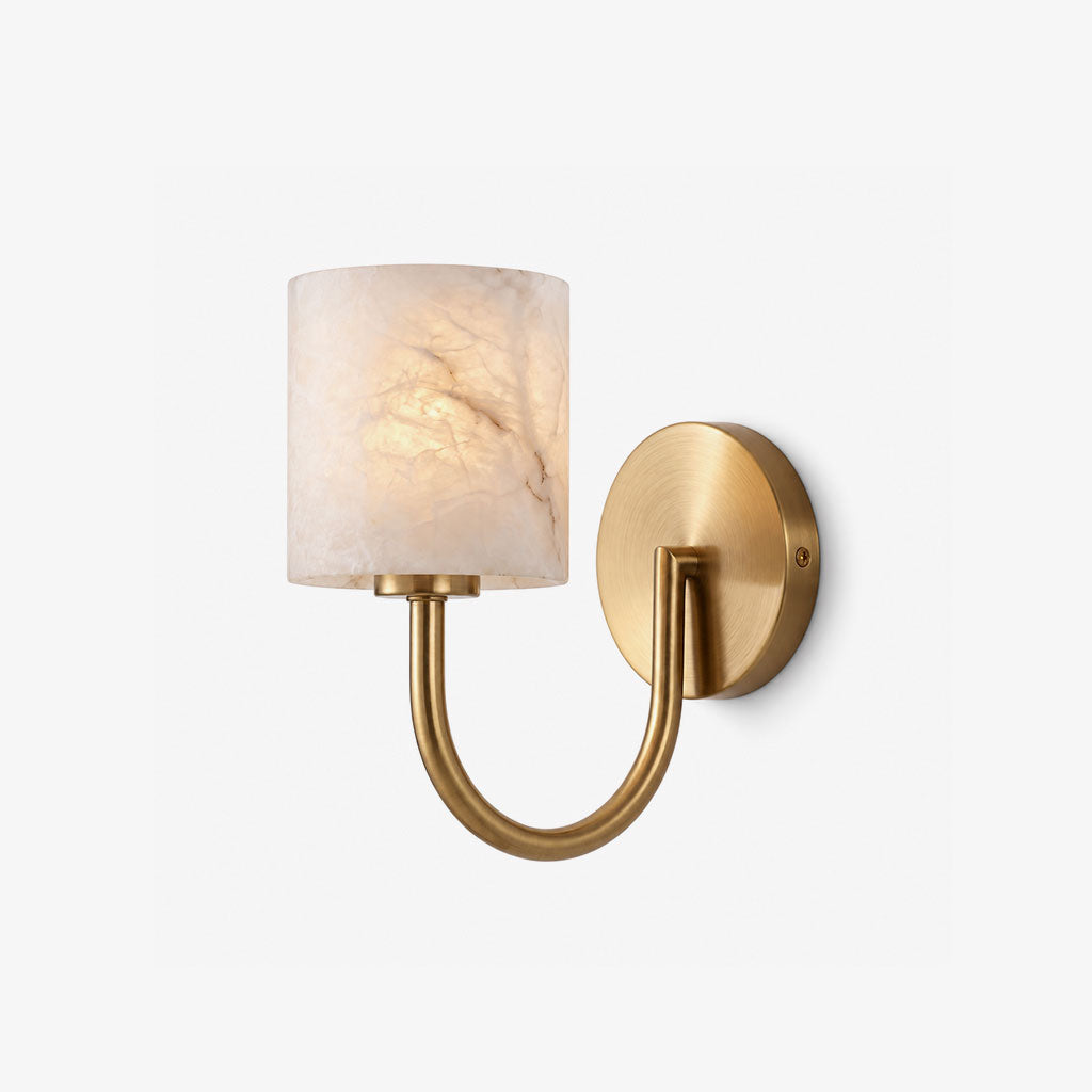 Cylindrical alabaster shade and curved brass arm on this Clérachic wall sconce, shown on a plain backdrop.