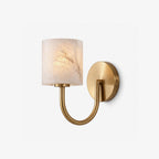 Cylindrical alabaster shade and curved brass arm on this Clérachic wall sconce, shown on a plain backdrop.