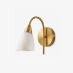 Cropped close against a plain backdrop, the brass finish of this Clérachic sconce tapers into a cone-shaped alabaster shade.