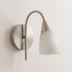 Shown close on a plain wall, this Clérachic sconce's nickel finish supports a forward-tilted alabaster cone.