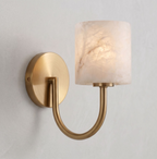 Warm light glows through the alabaster drum shade of this brushed brass Clérachic wall sconce.