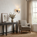 Beside a curtained window, a matte black Clérachic wall sconce glows above a dark console table.