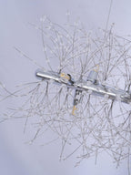 Close-up of a chrome mounting bar and fine crystal-tipped branches, a different Clérachic fixture from this round chandelier.