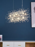A rectangular gold-bar pendant hangs against a deep navy wall above a white cabinet, a different Clérachic fixture from this chandelier.
