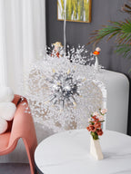 This Clérachic chandelier hangs above a small round table styled with dried flower stems and tiny bird figurines.