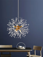 This Clérachic chandelier hangs lit above a dining table set with cups, framed by a deep navy wall.