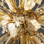 Extreme close-up of the gold centre hub on this Clérachic chandelier, showing several lit bulbs and converging branches.