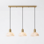 Seen in full against white, this brass Clérachic pendant fans three alabaster domes from a linear bar.