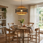 Wishbone chairs surround a round table beneath this Clérachic pendant in a brick-walled dining nook.