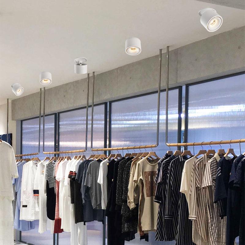 A row of assorted ceiling downlights, in shapes different from this Clérachic fixture, lights a clothing rail in a bright retail space.
