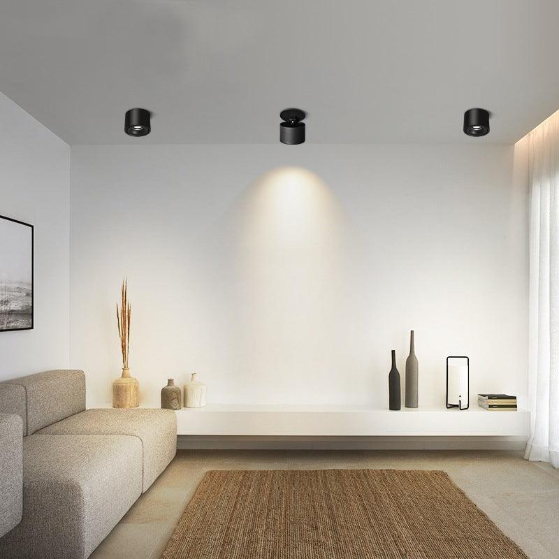 Black units of this Clérachic downlight light a living room with a beige sofa, jute rug and low side table.