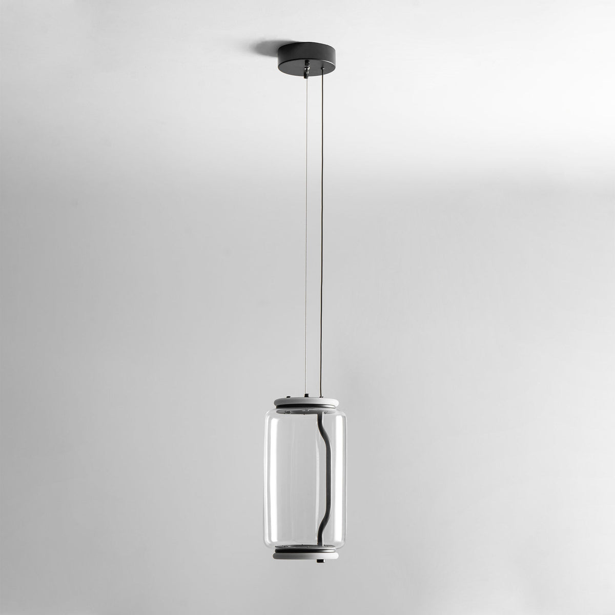 Studio shot of this Clérachic pendant's single small cylinder hanging from a long cord against a plain backdrop.
